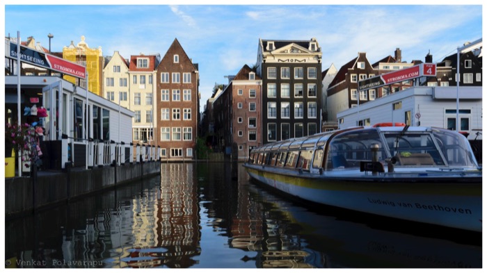 Amsterdam canal with a boat and canal houses
