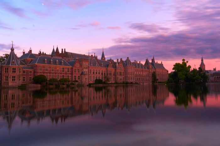 Binnenhof government buildings reflected in water at twilight
