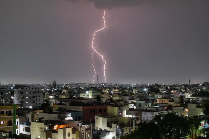 Lightning bolt over a city skyline at night